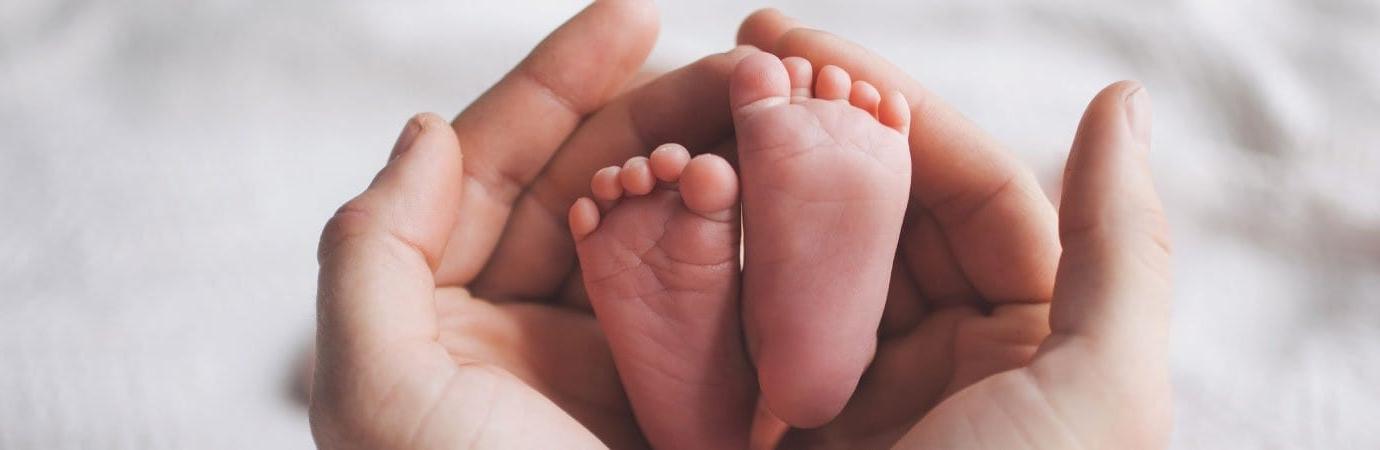 Mother's hands and baby feet